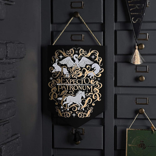 Decorative sign with 'Expecto Patronum' design on a dark surface