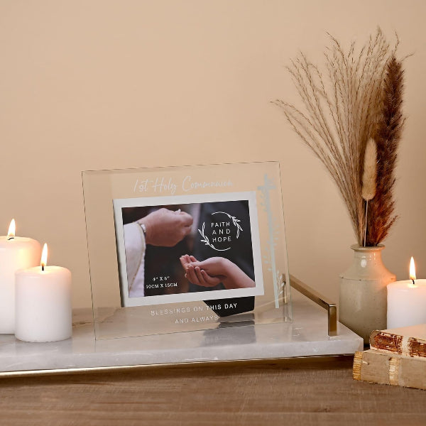 Decorative setup with framed photo, candles, and dried plants on a table.