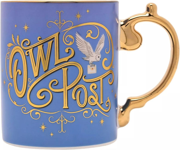 A blue ceramic mug with a gold handle and gold foil detailing spelling 'Owl Post' in an ornate script, featuring an illustration of an owl carrying a letter. The mug is shown on a clean white background.