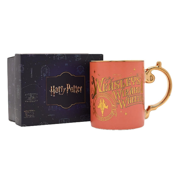 Harry Potter mug with gold handle and decorative text next to a matching box on a white background