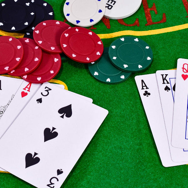 Poker chips and playing cards on a green felt table