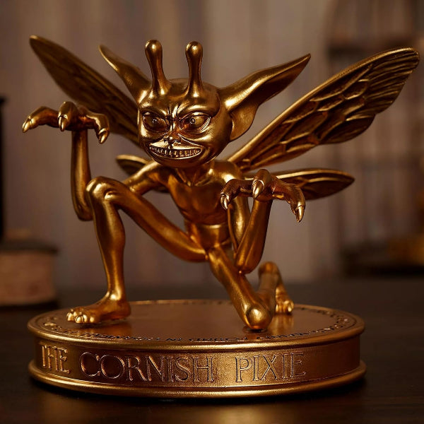 Gold statue of a Cornish Pixie on a dark background