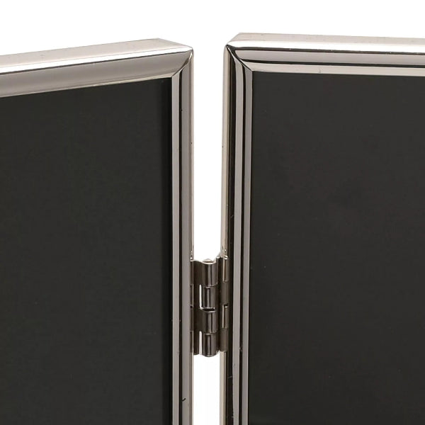 Close-up of a black rectangular object with a silver metallic frame and hinge.