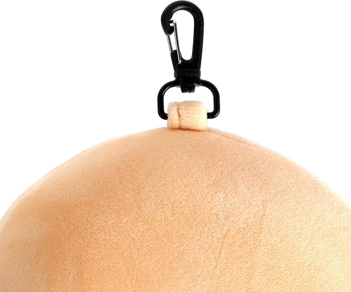 Round beige object with a black clip on a white background