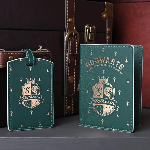 Hogwarts-themed Slytherin passport holder and luggage tag in front of a suitcase.