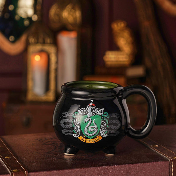 Black mug with Slytherin emblem on a wooden surface with a warm background