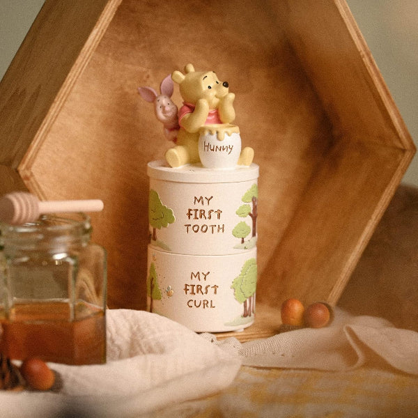 Stackable containers with cartoon characters and text, placed on a wooden surface with honey and apples.