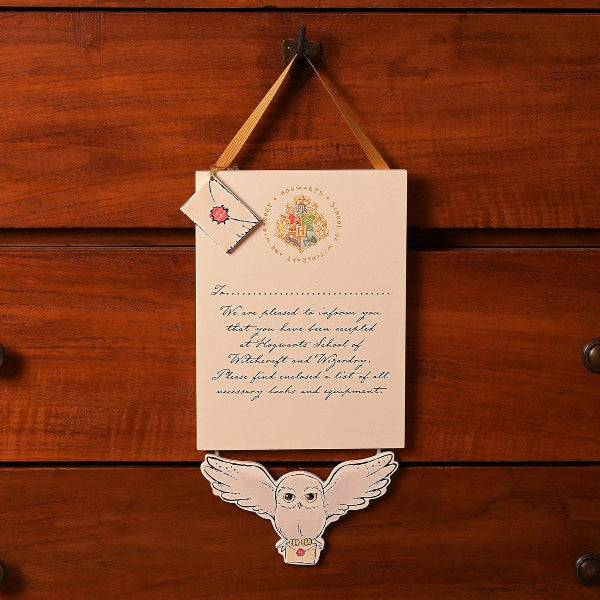 Hogwarts acceptance letter with owl decoration on a wooden background