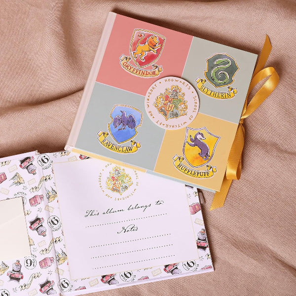 Notebook with Hogwarts house crests on a beige fabric background