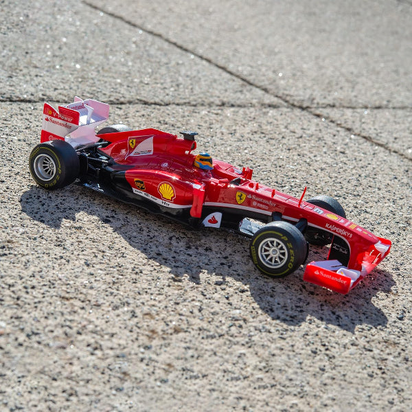 Red toy Formula 1 car on a textured surface