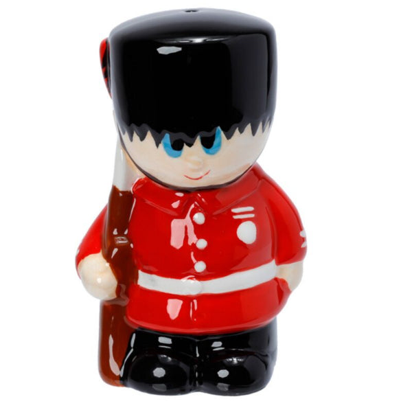 Ceramic figure of a British guard in red uniform with black hat on a white background
