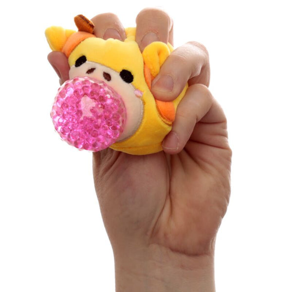 Hand holding a small plush toy with a pink glittery ball on a white background