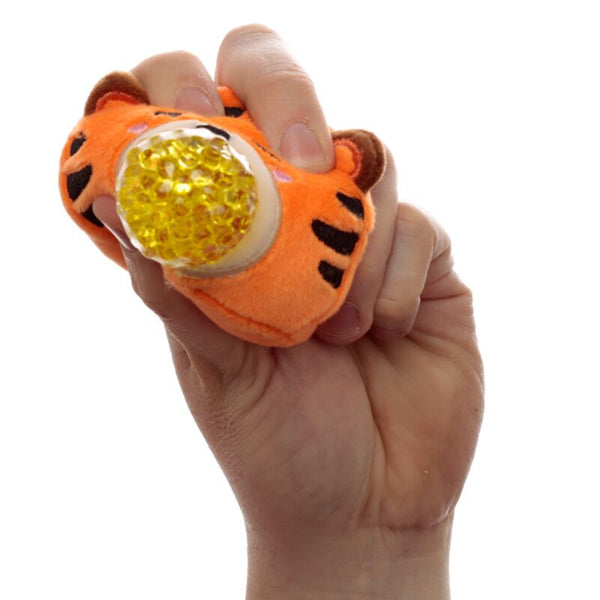 Hand holding an orange tiger-shaped toy with a yellow ball inside on a white background
