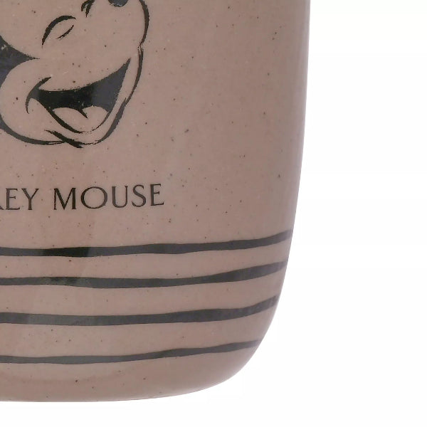 Close-up of a ceramic mug with a cartoon character design and 'Mickey Mouse' text.