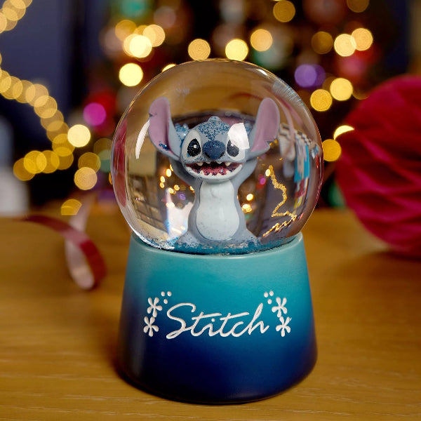 Snow globe with Stitch character inside, featuring a blurred festive background.