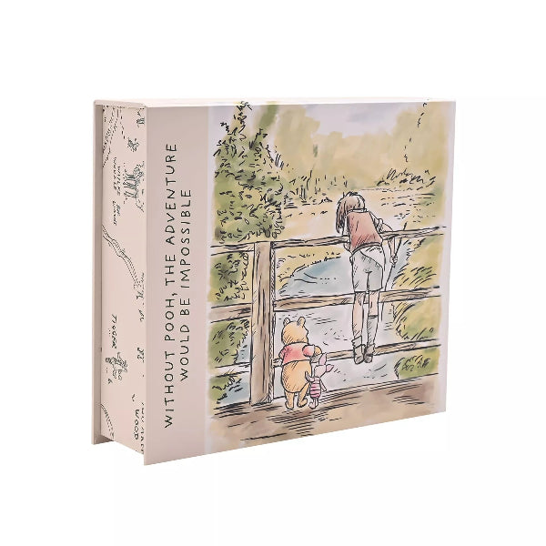 Book with illustration of a girl and Pooh bear on a bridge, featuring text 'Without Pooh, the adventure would be impossible'.