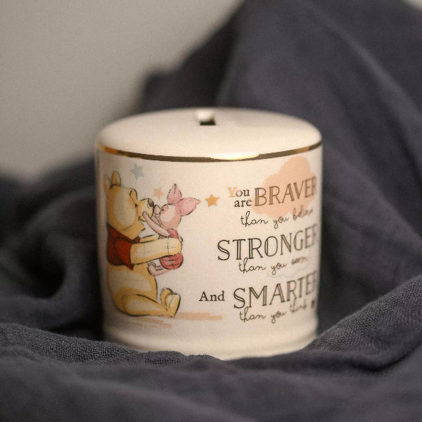 Ceramic jar with Winnie the Pooh and Piglet design and motivational quote on a dark fabric background