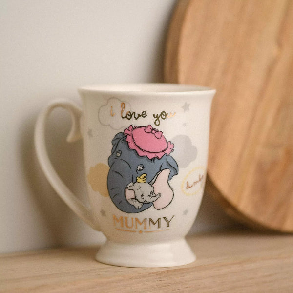 Mug with cartoon design of a elephant and baby, text 'I love you Mummy', on a wooden surface.