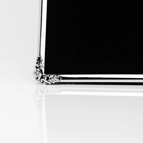 Decorative silver frame with intricate designs on a white background