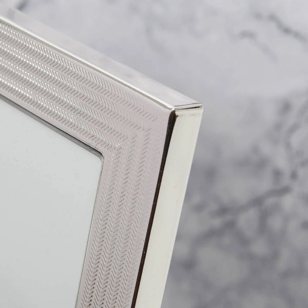 Close-up of a silver photo frame corner on a marble surface