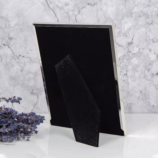 Black photo frame on a marble surface with lavender flowers