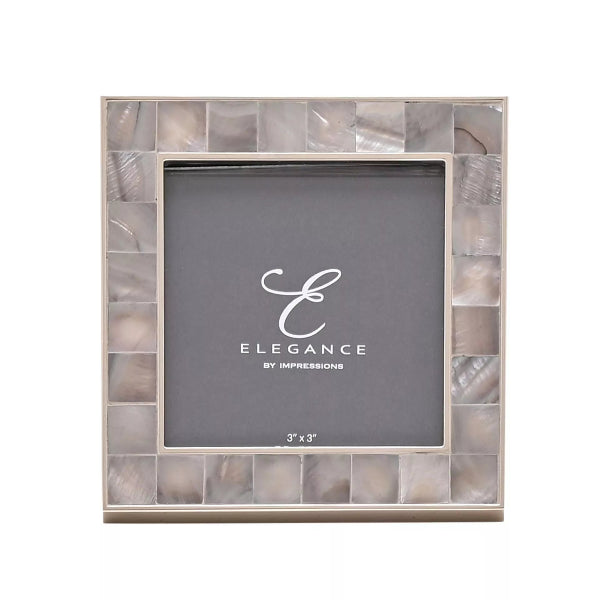 A square 3x3 picture frame with a mosaic border made of iridescent shell-like tiles in soft beige, gray, and white tones. The center insert is dark gray with the brand name 'Elegance by Impressions' printed in white.