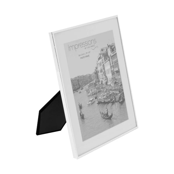 White photo frame with a black stand holding a scenic photograph of a cityscape.