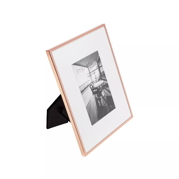 Rose gold photo frame with a black and white photo inside on a white background