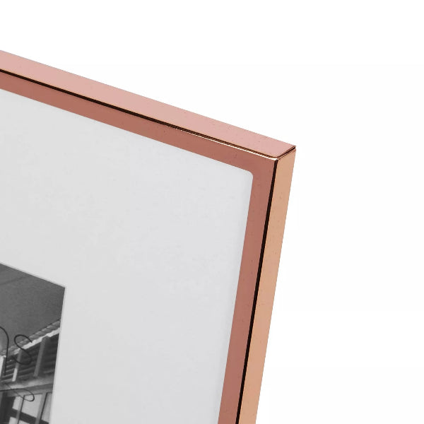 Close-up of a rose gold picture frame corner on a white background