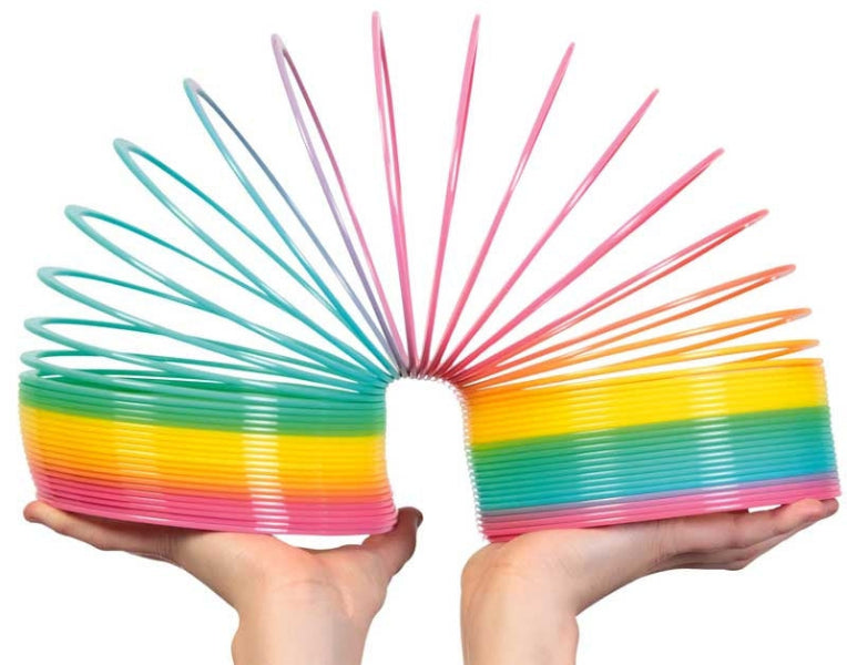 Colorful spring toy held in hands against a white background