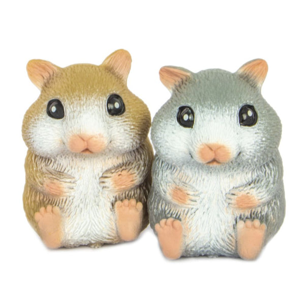 Two small hamster figurines side by side on a plain white background. One is tan and white, and the other is gray and white, both with peach-colored feet and noses and large black eyes.