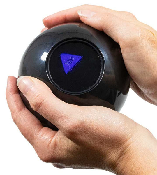 Black crystal ball with a purple 'Yes' triangle inside, held by hands against a white background