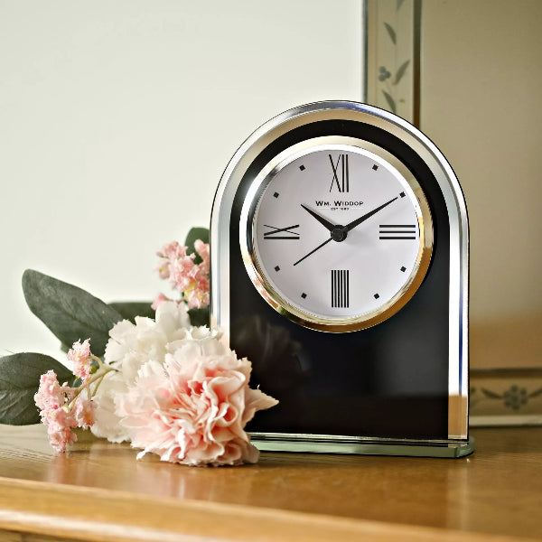 Decorative clock with floral arrangement on a wooden surface